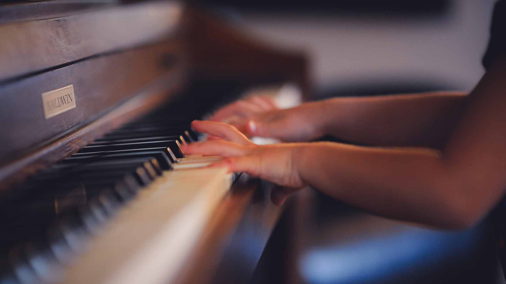 young child playing piano and creating a positive habit.